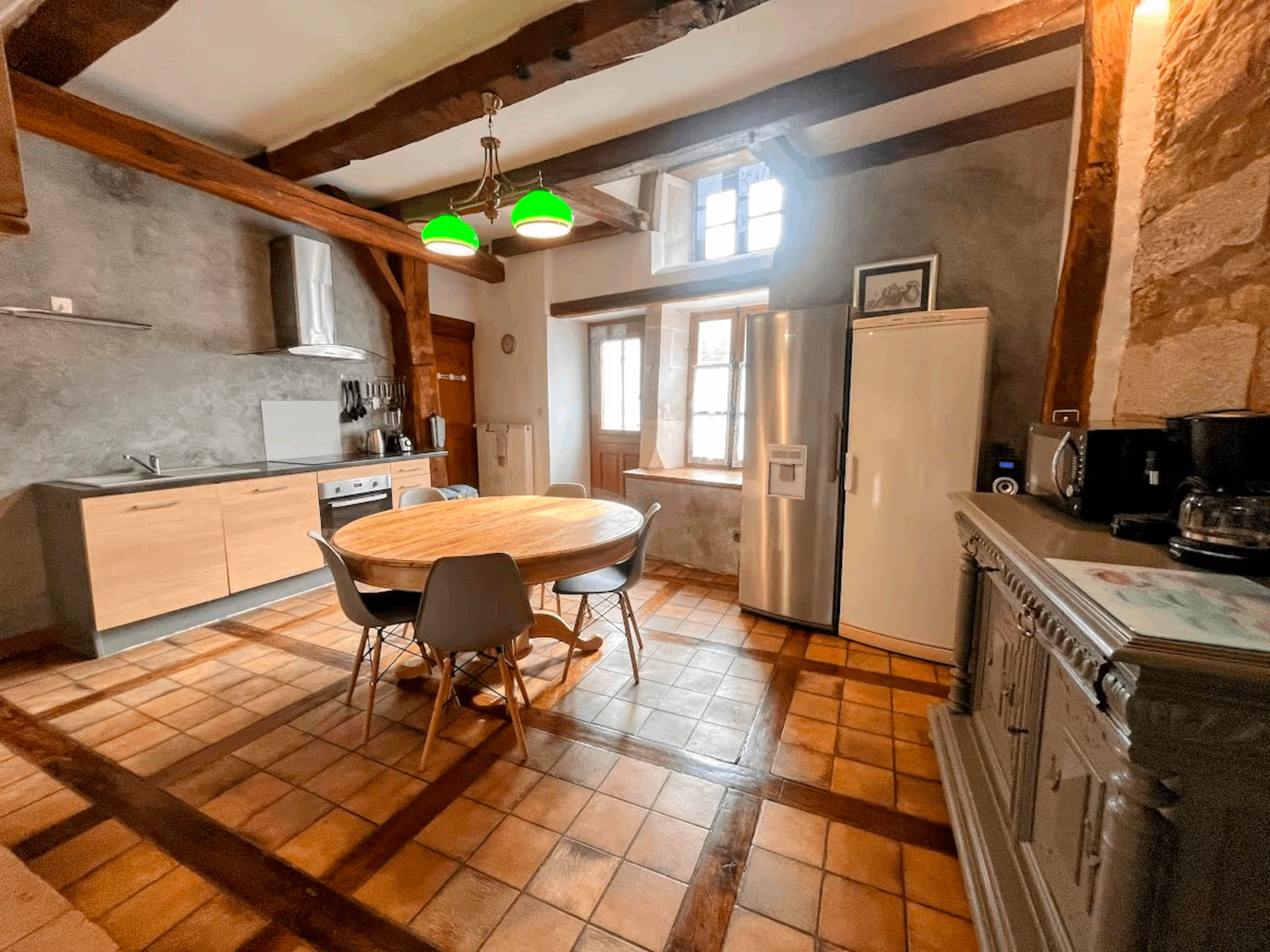 Kitchen with beamed ceiling, terracotta tile floor, and round table