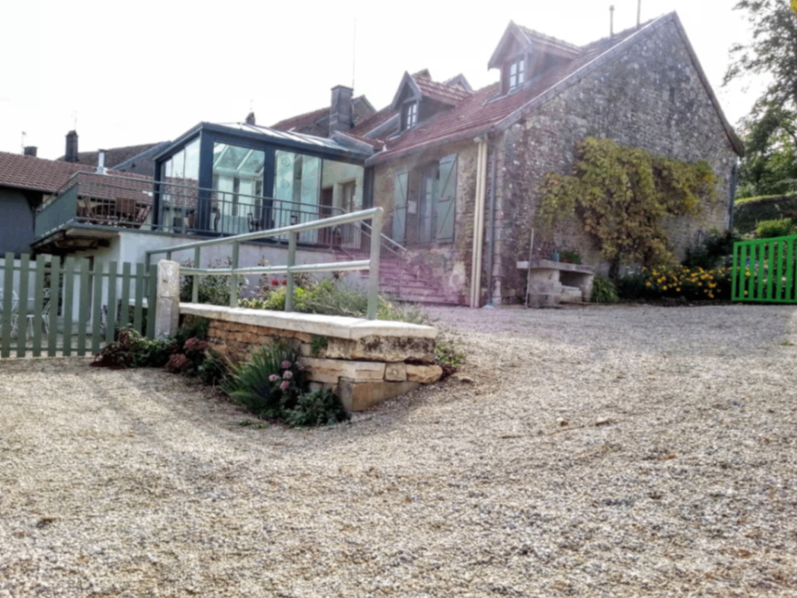 Exterior of the stone house and gravel courtyard with the veranda