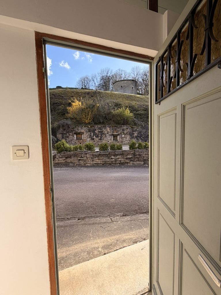 Open front door looking out to the hillside and old stone tower