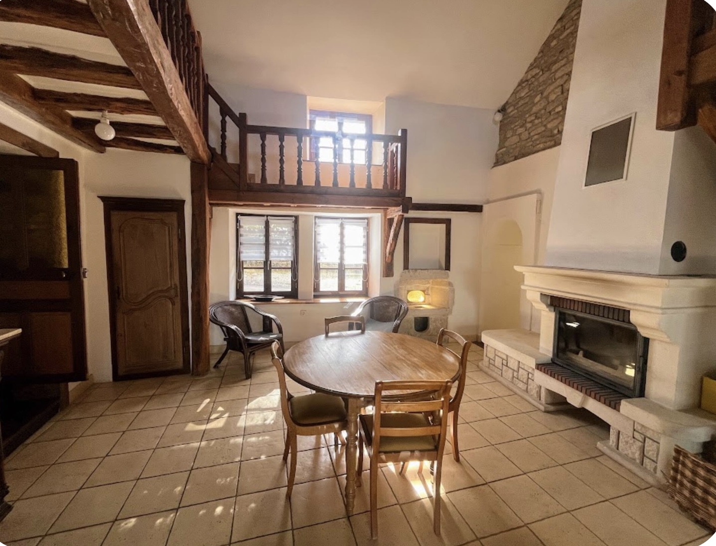 Beamed living room with stone fireplace and mezzanine balcony